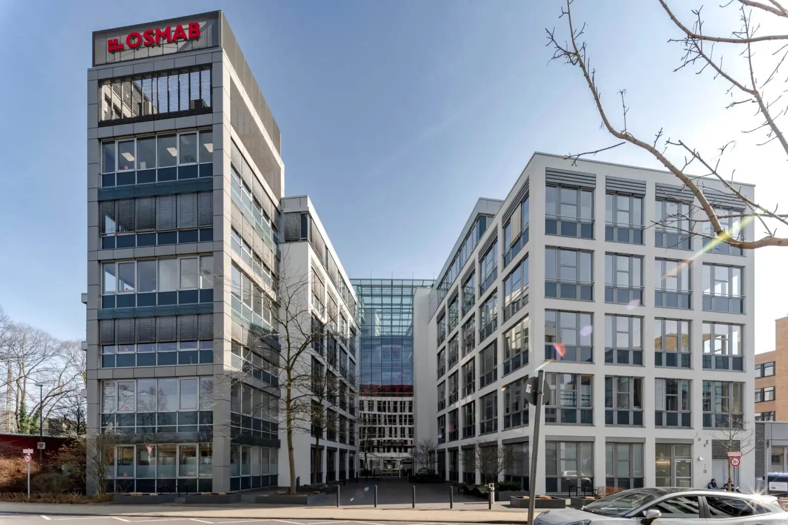 Blick auf das moderne Bürogebäude in Hamburg mit Glasfassaden und Firmenlogo.
