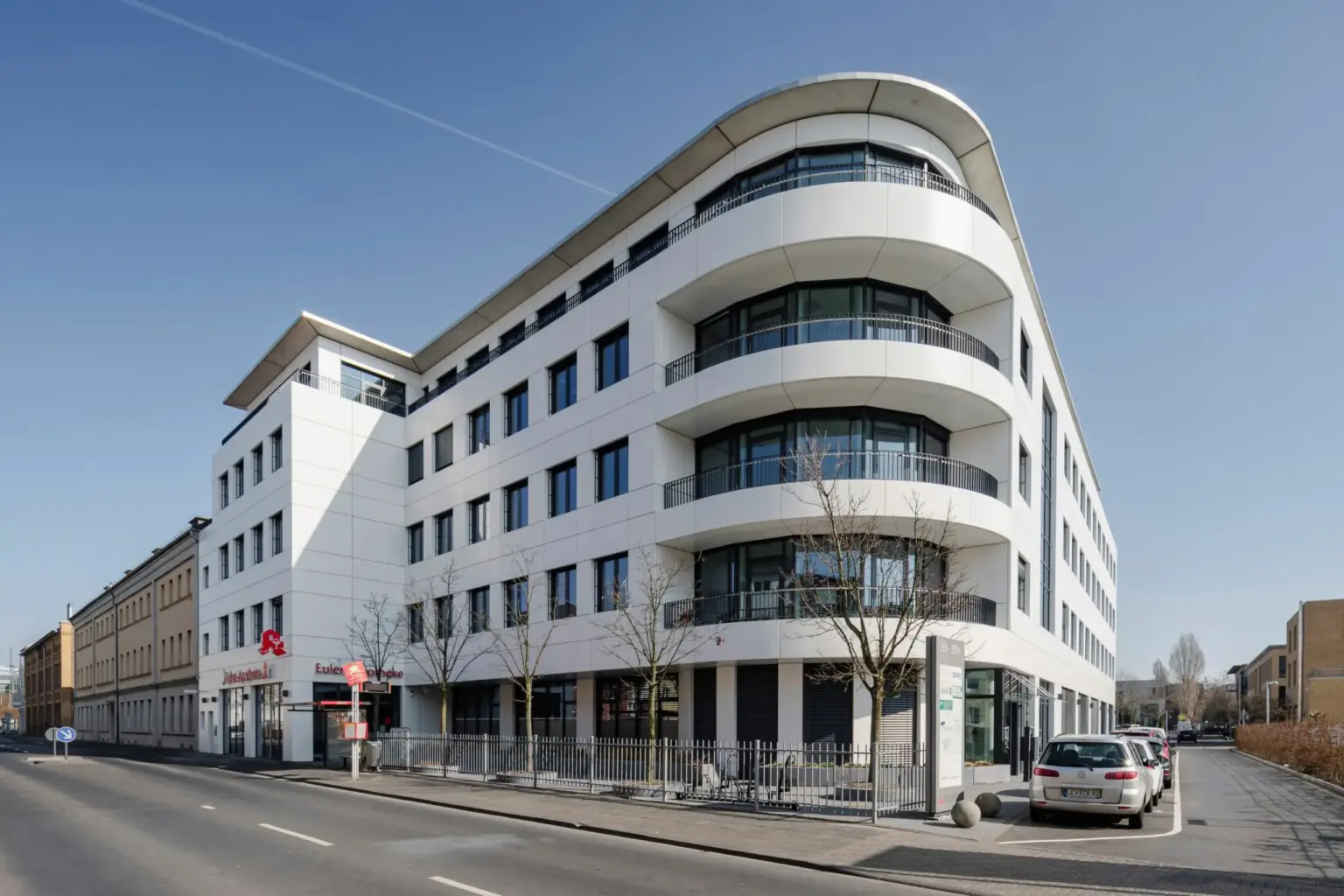 Zeitgenössisches Bürogebäude in Hamburg mit runden Balkonen und Glasfassade.