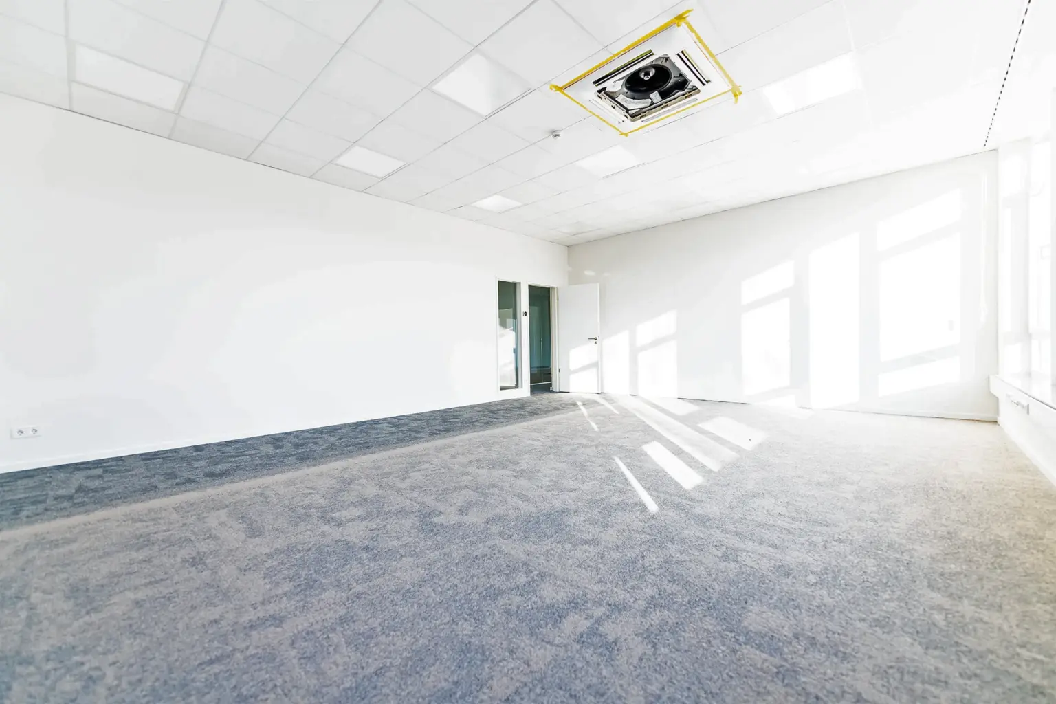 Leere Büroräume mit viel Tageslicht, ideal für flexible Arbeitsplätze.