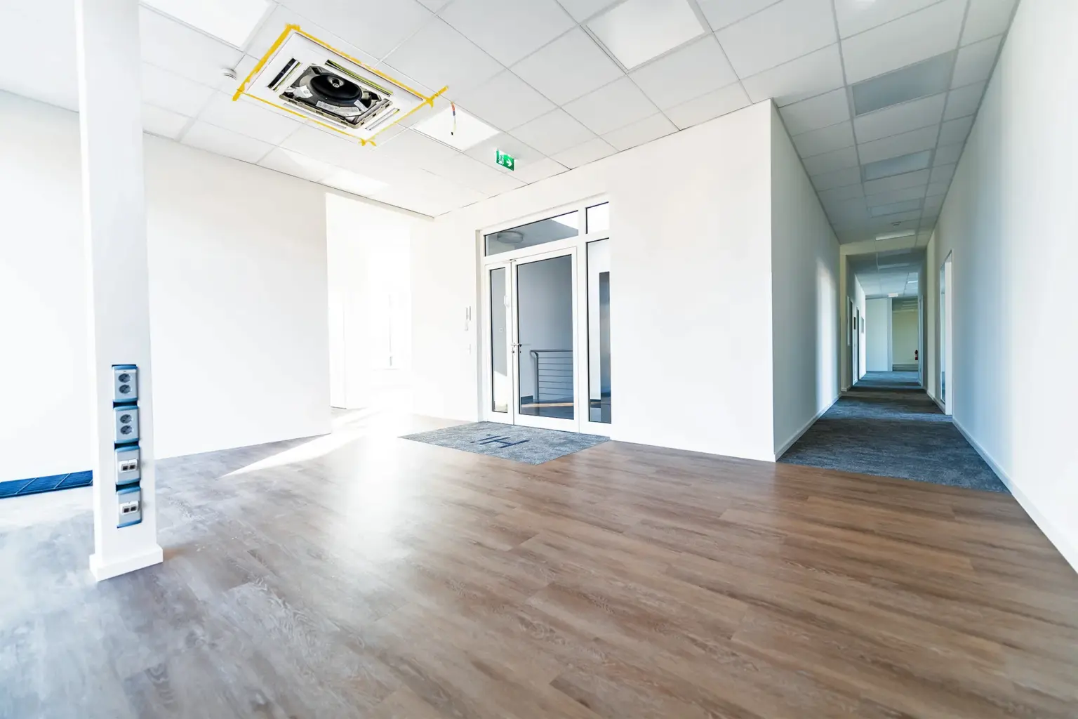 Innenraum eines modernen Büros mit hellem Design, Holzfußboden und Flur.